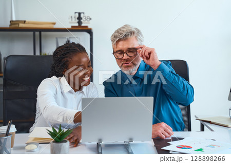 Team Collaboration Between Colleagues Working Together On Presentation At Office Desk 128898266