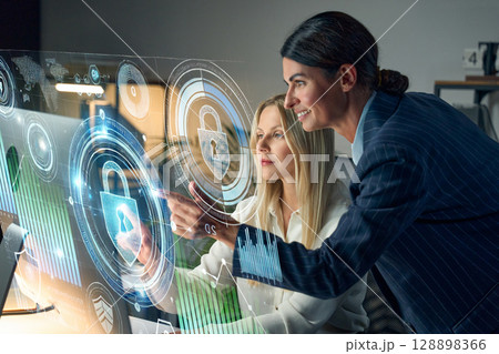 Team Analyzing Cybersecurity Data on Interactive Digital Display in Modern Office 128898366