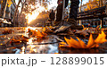 Street cleaner sweeping autumn leaves at sunrise in a city 128899015