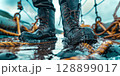 Fisherman walking on wet deck with waterproof boots 128899017