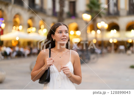 young woman walks through the evening streets of Barcelona young woman walks through the evening streets of Barcelona 128899043