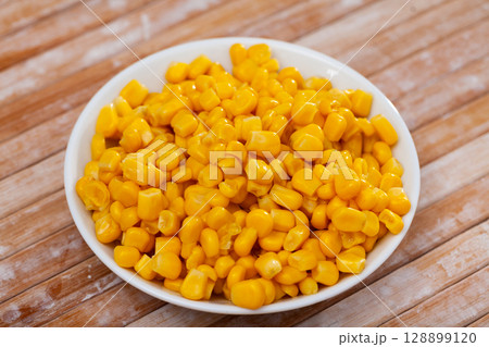 Sweet canned corn in bowl on table Sweet canned corn in bowl on table 128899120