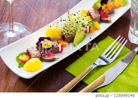Tasty fried tuna with mango and avocado, served with fig and flower 128899146