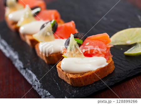 Canapes with salmon and black olives on cream sauce Canapes with salmon and black olives on cream sauce 128899266