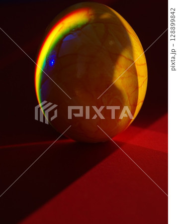 A yellow egg with a rainbow reflection on it A yellow egg with a rainbow reflection on it 128899842