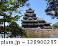 木の陰から眺める、夏空に映える松本城 128900285