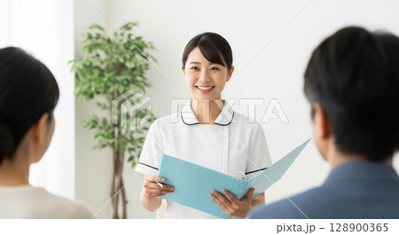 患者の家族に説明をするアジア人看護師 128900365