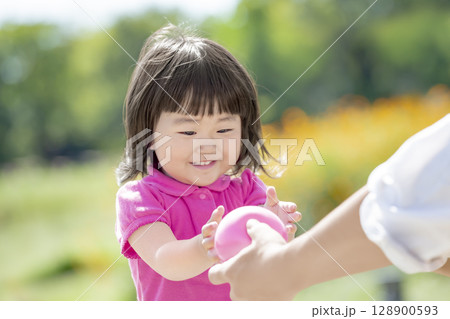 公園で父親からボールをもらう娘 公園で父親からボールをもらう娘 128900593