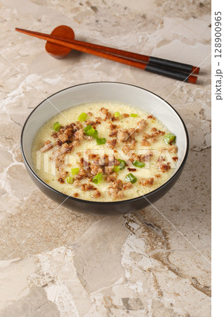 Asian Steamed Eggs with fried Pork mince and green onion closeup in the bowl. Vertical Asian Steamed Eggs with fried Pork mince and green onion closeup in the bowl. Vertical 128900965