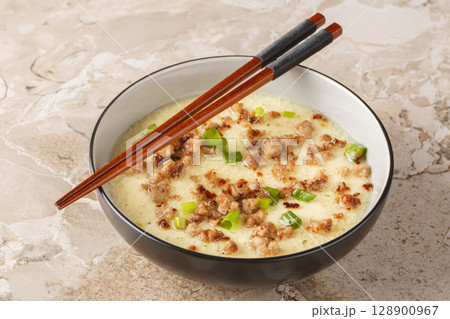 homemade steamed egg with crispy minced pork and green onion closeup in the bowl. Horizontal homemade steamed egg with crispy minced pork and green onion closeup in the bowl. Horizontal 128900967