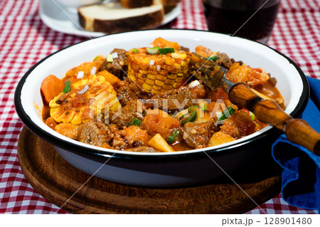 Delicious beef stew called carbonada with potatoes, corn, and carrots simmering in a rustic bowl 128901480