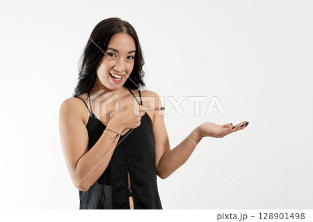 Young woman pointing and showing with open hand on white background Young woman pointing and showing with open hand on white background 128901498