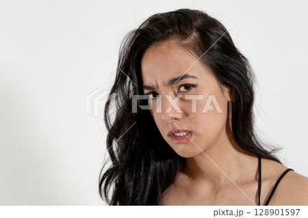 Young latin woman expressing anger and frustration on white background Young latin woman expressing anger and frustration on white background 128901597