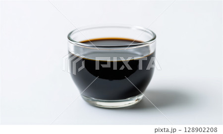 透明なカップに注がれた黒酢のシンプルな静物写真 128902208