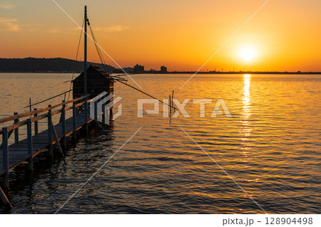 東郷湖の夕景　四手網漁の監視小屋と夕陽 128904498