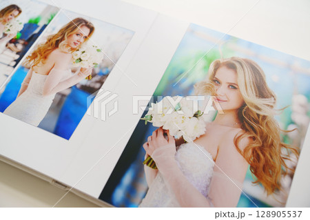 the pages of a photo book with wedding photos.  128905537