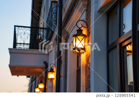 A modern building in a classic style with French balconies. evening lighting  A modern building in a classic style with French balconies. evening lighting  128905541