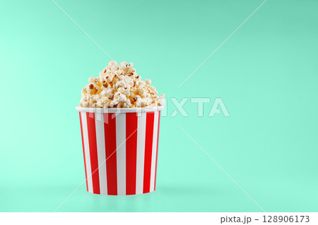 Classic red striped popcorn cardboard cup on Green background 128906173