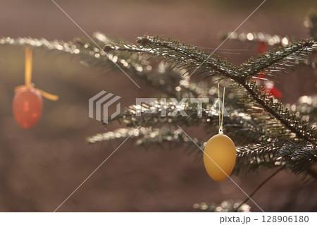 A tree with two eggs hanging from it 128906180