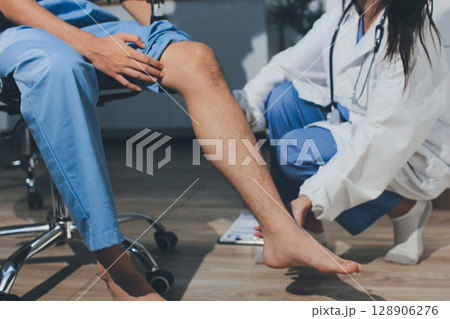 Physical therapist teaching a patient how to do exercises for his knee pain 128906276