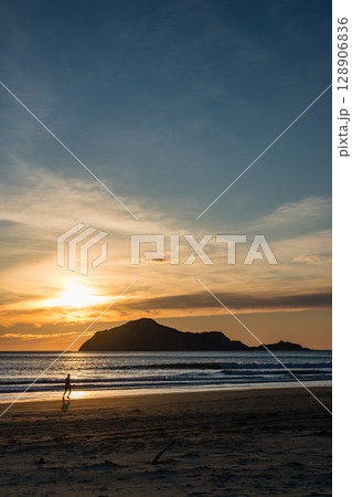 ニュージーランド　ホークスベイのヘイスティングスにあるワイマラマビーチからの早朝のベア島と昇る太陽 128906836