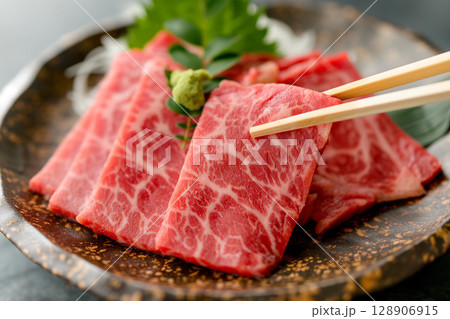 箸で持ち上げた霜降り和牛｜美しいサシが入った高級和牛のクローズアップ 128906915