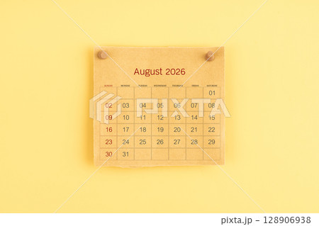 August 2026 brown calendar with wooden thumbtack on yellow color background. 128906938
