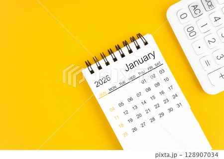 January 2026 calendar and calculator on yellow background, Flat lay. 128907034