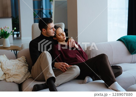 Couple relaxing together on a comfortable sofa in a cozy living room 128907880