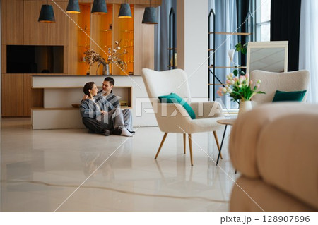 Cozy moment between a couple in a modern living room setting Cozy moment between a couple in a modern living room setting 128907896