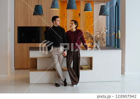 Young couple enjoying time together in a modern kitchen during the day Young couple enjoying time together in a modern kitchen during the day 128907942