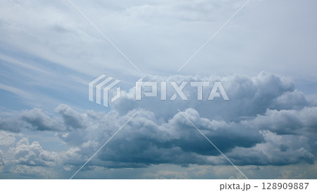 A Dramatic Cloudscape Set Against a Bright Blue Sky, Evoking a Sense of Wonder and Calmness A Dramatic Cloudscape Set Against a Bright Blue Sky, Evoking a Sense of Wonder and Calmness 128909887