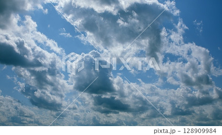 A beautiful and scenic cloudy sky with a vibrant blue atmosphere pleasantly overhead 128909984