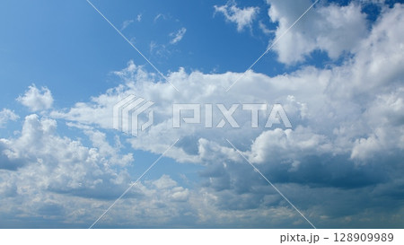 A Beautiful and Cloudy Sky Overcast with a Stunningly Bright Blue Background behind it 128909989