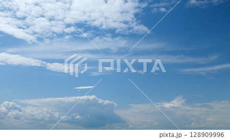 A Beautiful Blue Sky filled with Fluffy Clouds drifting gracefully in the atmosphere A Beautiful Blue Sky filled with Fluffy Clouds drifting gracefully in the atmosphere 128909996