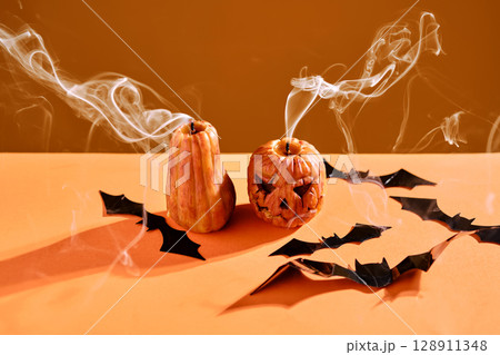 Halloween-style candles on a orange background. Festive decor. Halloween-style candles on a orange background. Festive decor. 128911348