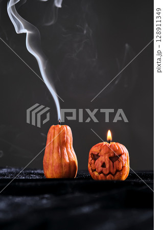 Halloween-style candles on a dark background. Festive decor. Halloween-style candles on a dark background. Festive decor. 128911349
