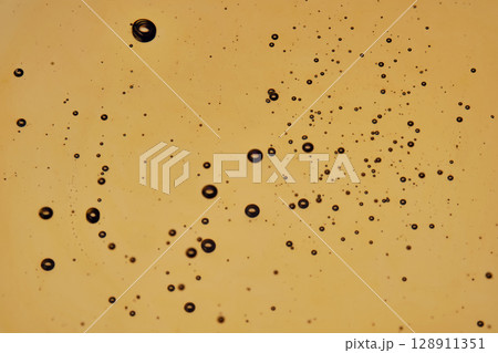 Golden background with oil and bubbles. Golden background with oil and bubbles. 128911351