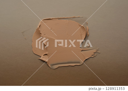 The texture of foundation on a beige background. 128911353