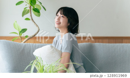 リビングのソファに座る笑顔の女性 128911969