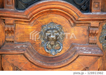Ornate Wooden Door with Lion's Head Knocker 128911982