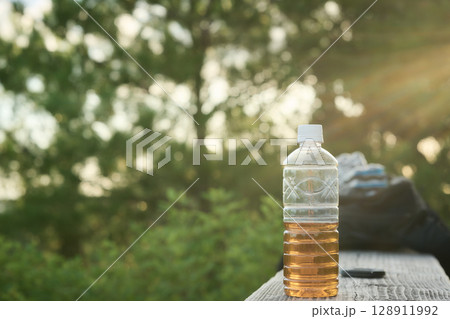 ハイキングに持って行ったお茶が入ったペットボトル 128911992