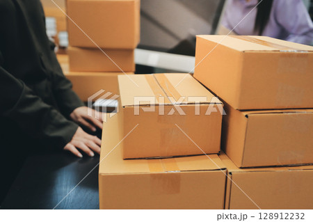 Portrait of Starting small businesses SME owners, two Asian woman check online orders Selling products working with boxs freelance work at home office, sme business online small medium enterprise Portrait of Starting small businesses SME owners, two Asian woman check online orders Selling products working with boxs freelance work at home office, sme business online small medium enterprise 128912232