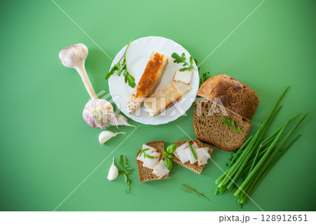 Traditional Ukrainian dish with lard and greens on a green background Traditional Ukrainian dish with lard and greens on a green background 128912651