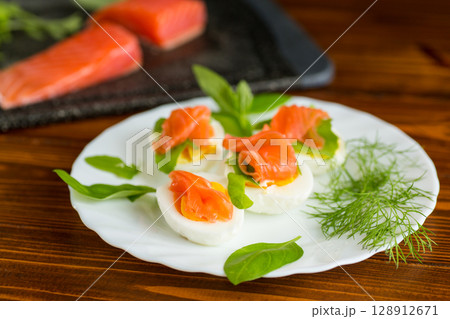 Cold festive appetizer of eggs with fish slices Cold festive appetizer of eggs with fish slices 128912671