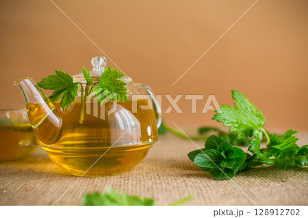 Natural tea from currant leaves and mint in a teapot Natural tea from currant leaves and mint in a teapot 128912702