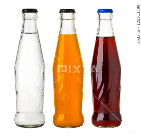 Three glass soda bottles with colorful liquid standing on white background Three glass soda bottles with colorful liquid standing on white background 128913399
