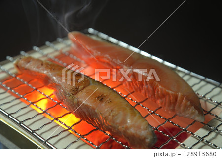 煙りの立ち昇る七輪で鮭を焼く 128913680