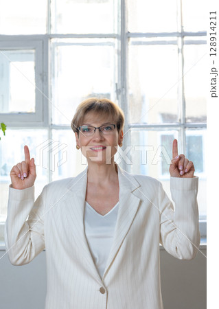 Portrait of emotional woman. Confident woman showing direction with hand. Looking at camera, banner. Vertical photo. High quality photo Portrait of emotional woman. Confident woman showing direction with hand. Looking at camera, banner. Vertical photo. High quality photo 128914211