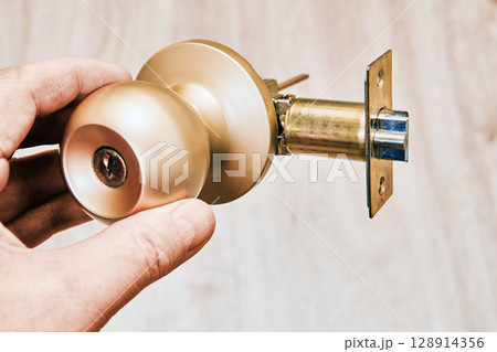 Door locking mechanism with cylindrical latch and brass handle features intricate metalwork, secure locking system, smooth operation design. 128914356